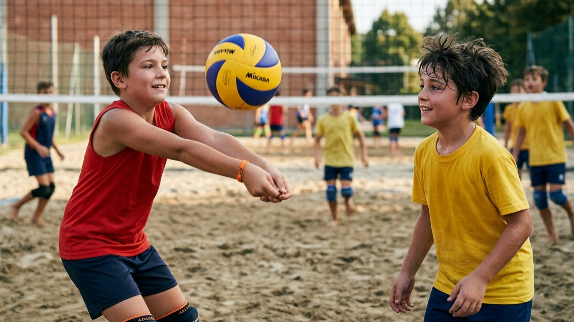 Bambini di 10 anni che giocano a pallavolo in un campo di sabbia